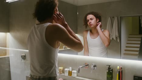 man washing face in bathroom