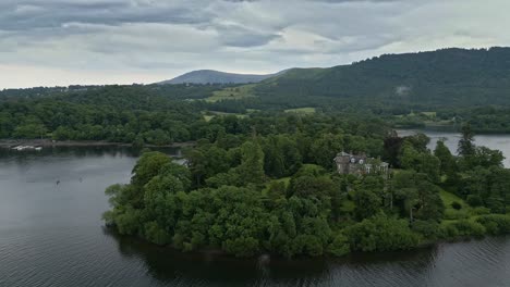 aerial footage of derwent island on derwentwater, keswick, a calm lake with river boats and a stormy sky