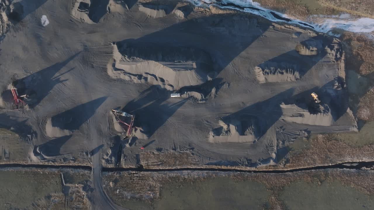 Cinematic overhead scene shows multiple rock heaps forming patterns in quarry