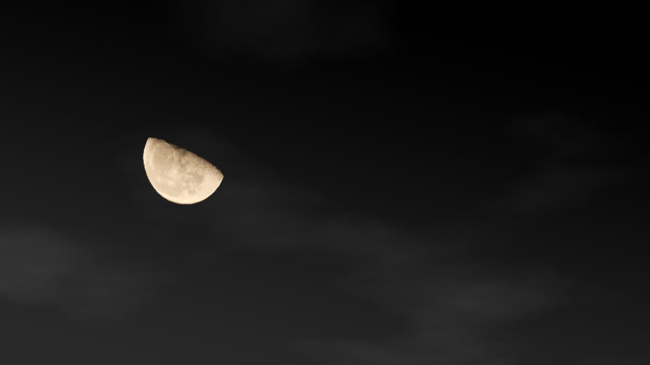 Timelapse da Lua em Quarto Minguante Viajando em Arco Pelo Céu Noturno com Gráficos de Nuvens ao Fundo