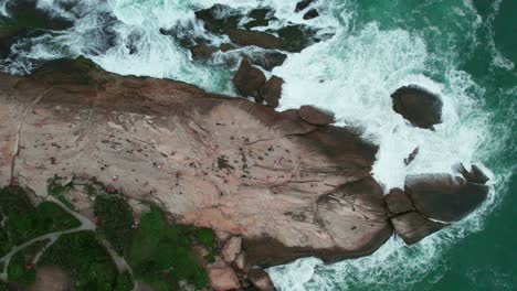 topdown view of famous pedra do arpoador, rocky peninsula with ocean waves crashing, rio de janeiro