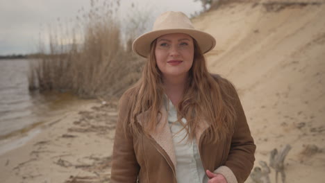 an beautiful curvy red haired female walking happy next to a lake