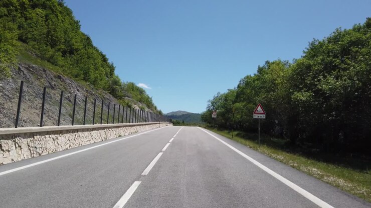 Veduta in movimento (auto, moto o bicicletta) di un paesaggio montano
