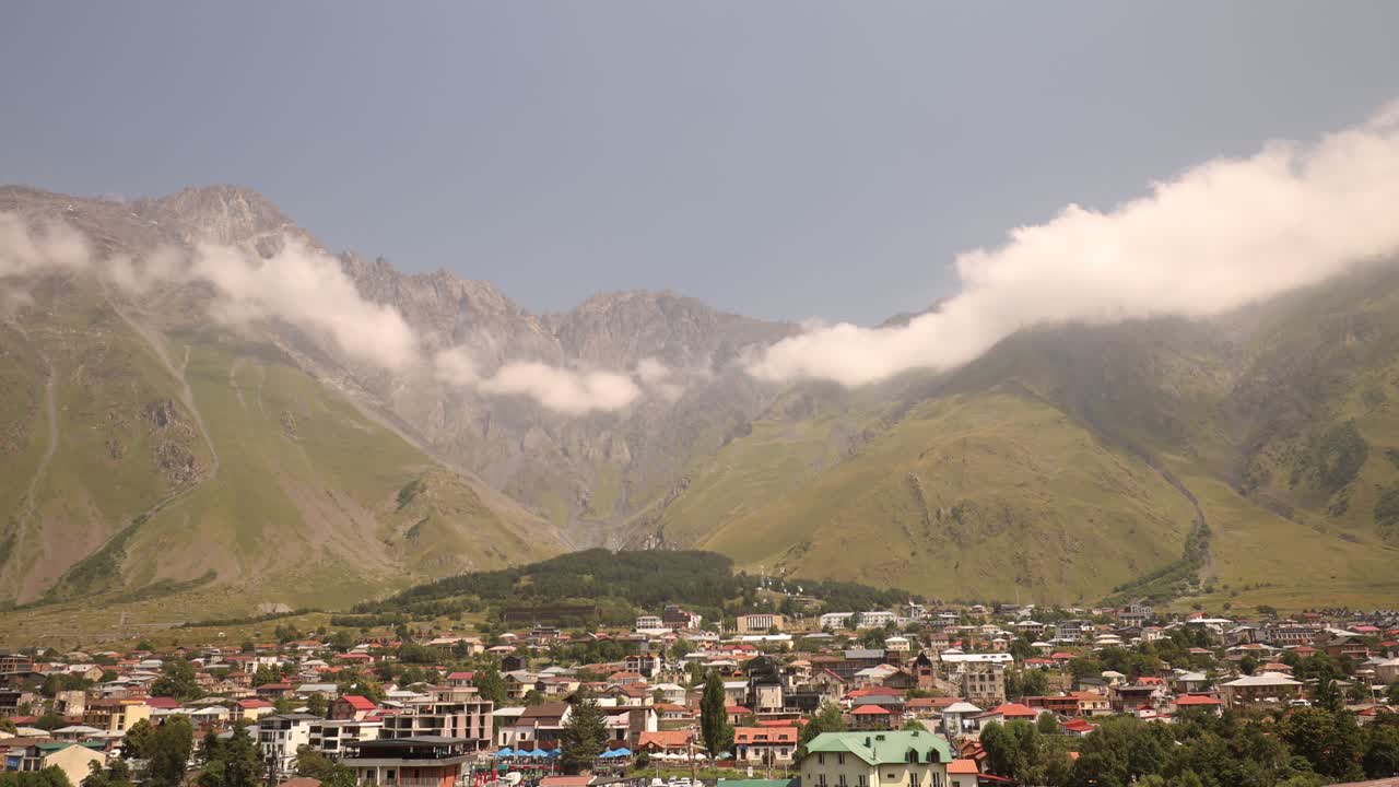 picturesque Village in mountainous valley with rolloing cloudscape over mountain peaks, north Georgia