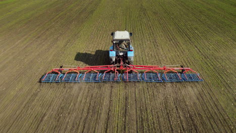 a picturesque landscape - a tractor in the field in the spring cultivates the earth 1