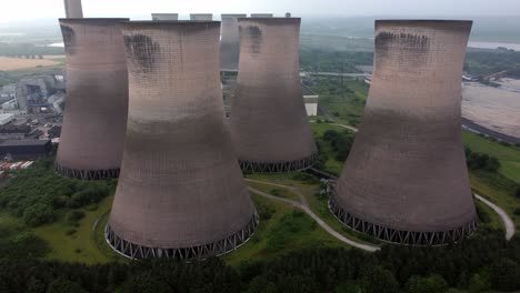 disused industrial energy power plant cooling smoke stake chimneys aerial view pushing in