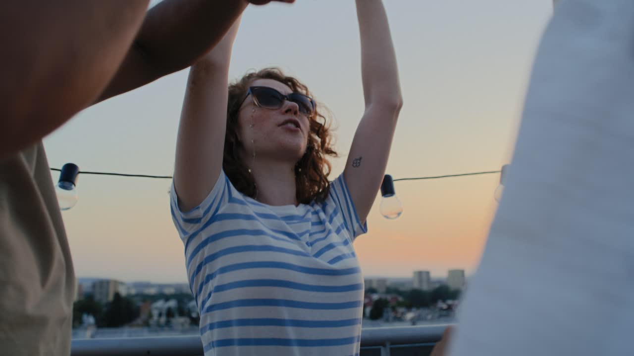 amigos caucásicos bailando en la fiesta en la azotea.