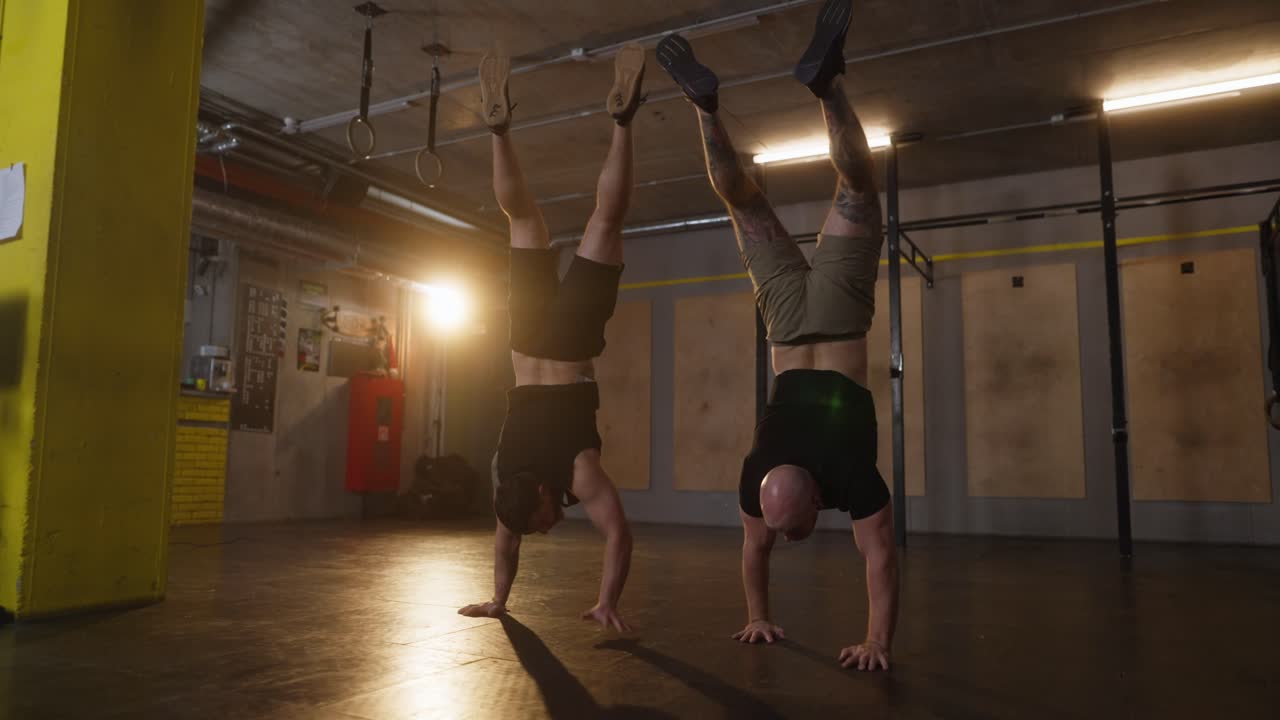 Men Performing Handstands in Gym