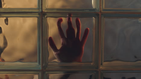 hand touching window behind glass creepy stalker concept