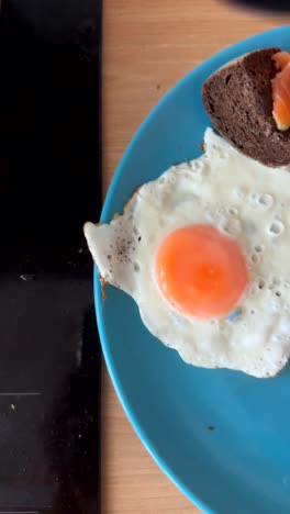 cooking and serving a fried egg with salmon and bread