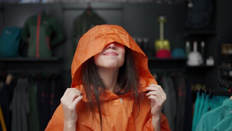 A-woman-trying-colorful-raincoat-at-the-sportive-store