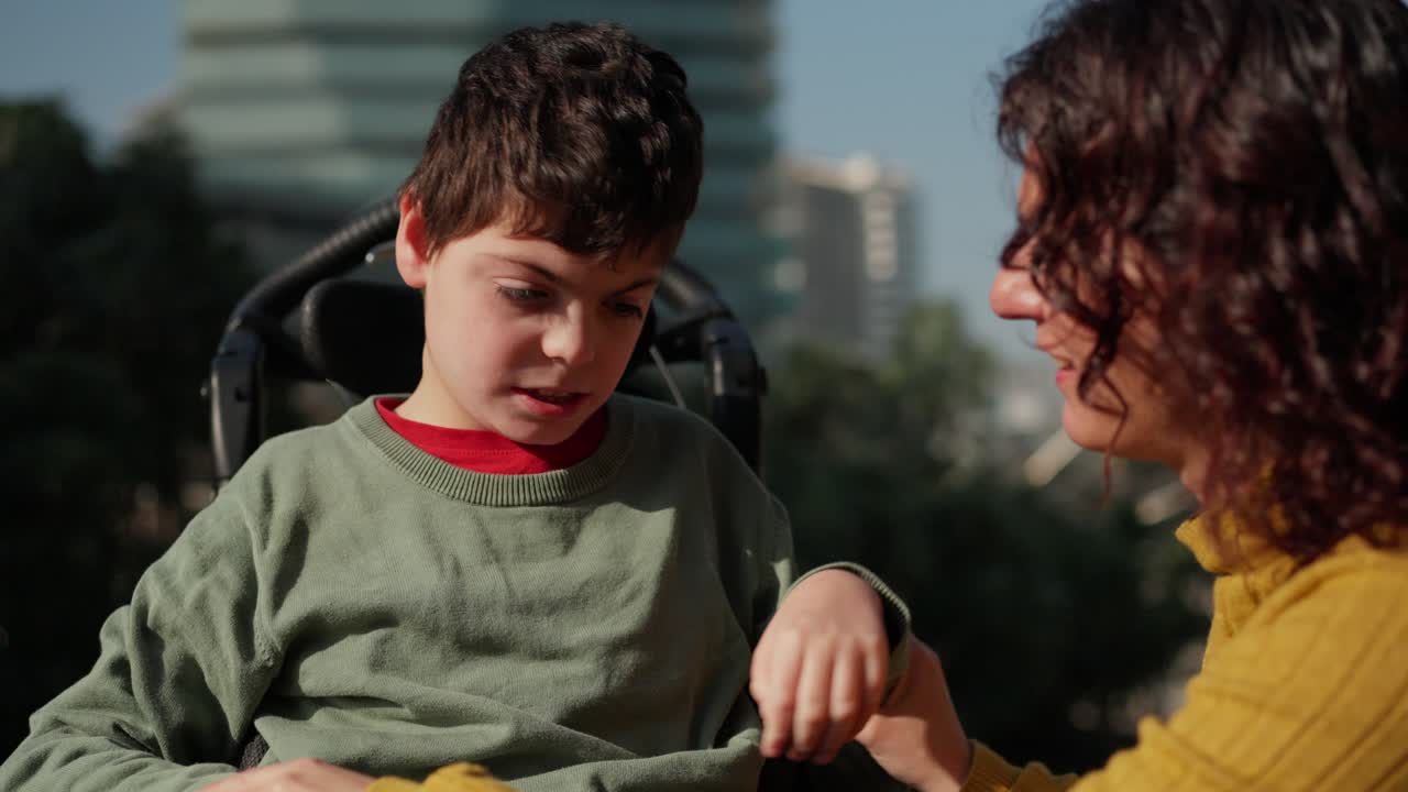 Child in wheelchair interacting with a woman