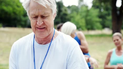 Senior-volunteer-writing-on-clipboard-in-the-park