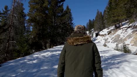 Man-walking-on-snowy-path-in-slow-motion