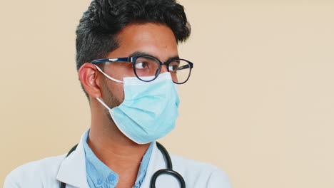 face portrait of doctor cardiologist man lab worker in glasses looking at camera in medical mask