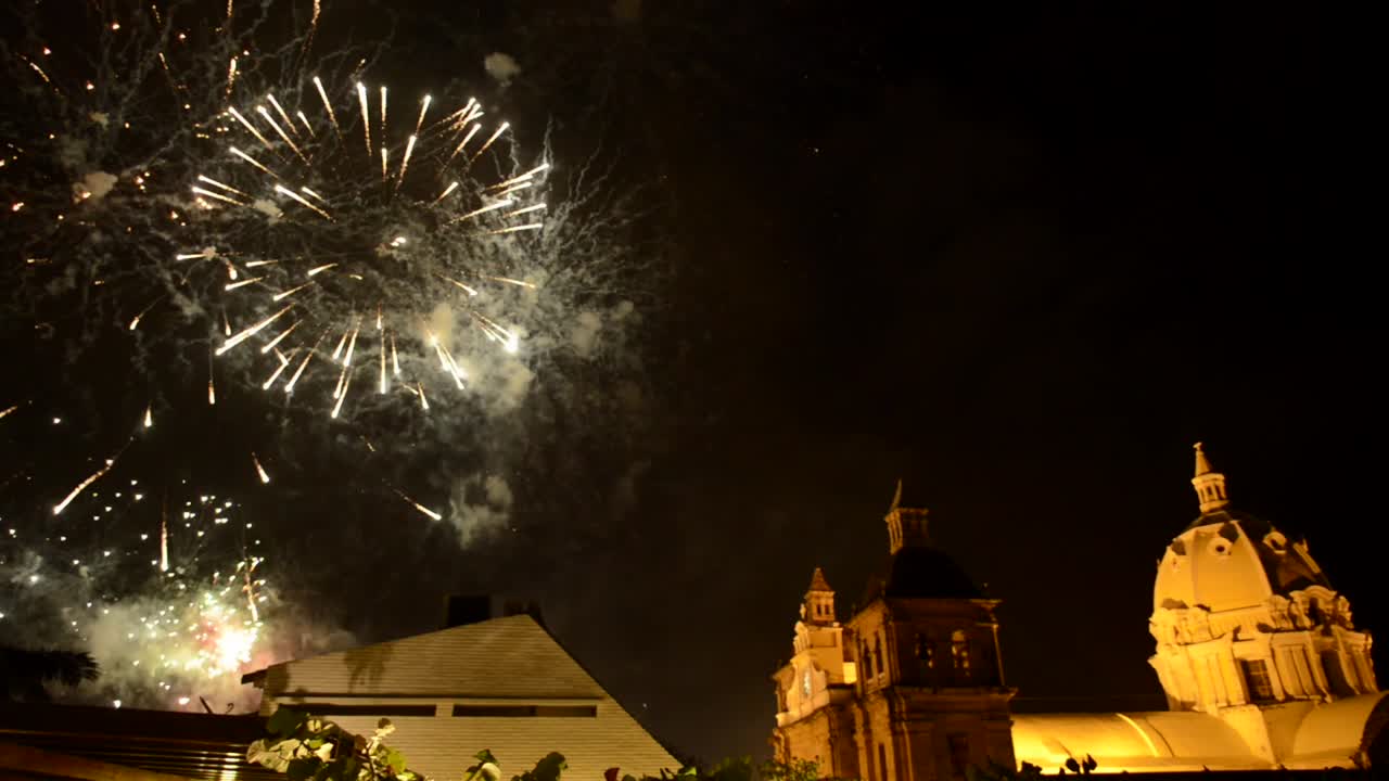 Scena notturna romantica e sognante di Cartagena, Colombia, con la Cappella di San Pietro sullo sfondo mentre i fuochi d'artificio esplodono nel cielo