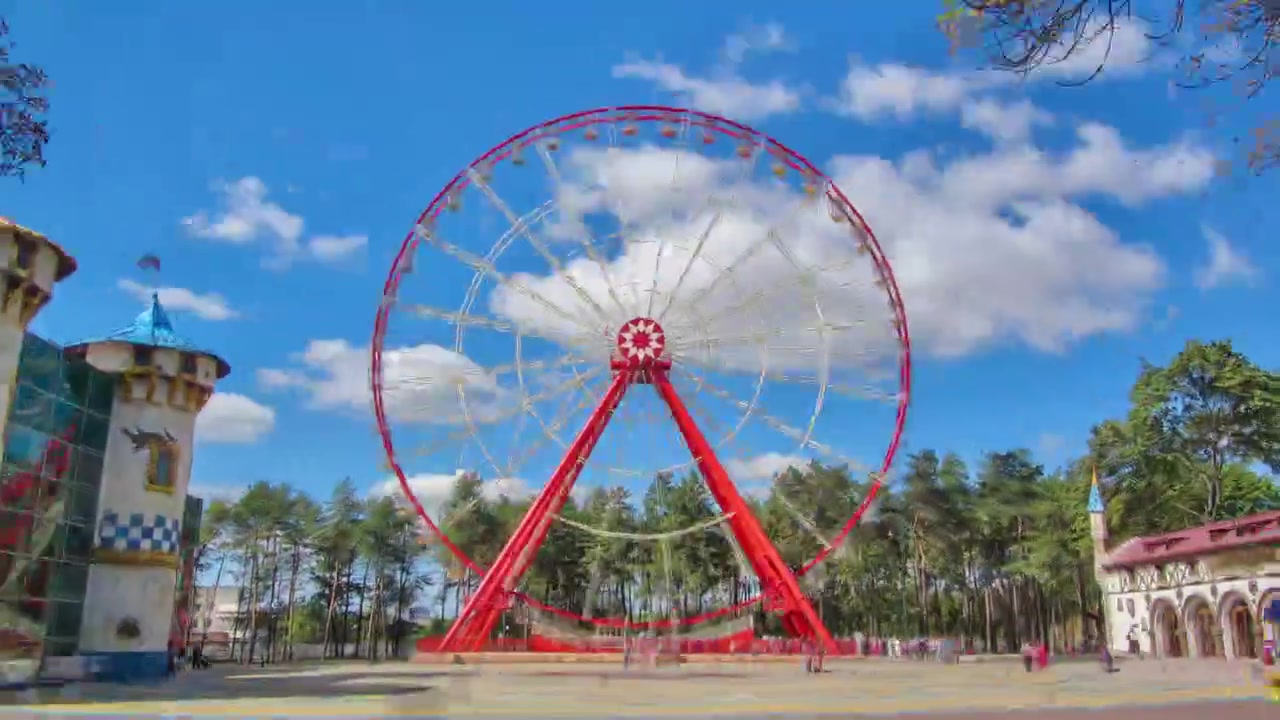 Roda-gigante no Parque Central de Cultura e Lazer Gorky em Carcóvia, timelapse hyperlapse, Ucrânia. Vista da alameda principal em um dia ensolarado com nuvens em um céu azul