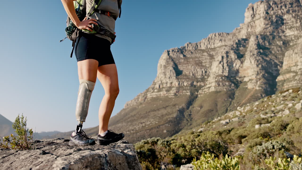 mujer con pierna protésica caminando por las montañas