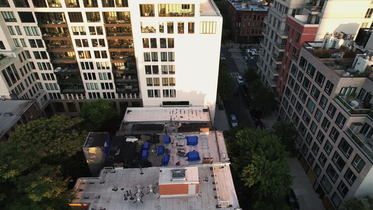 Vista aerea davanti a un palazzo che rivela il centro di Brooklyn, all'ora d'oro a NY, USA - in movimento, inclinata, ripresa con drone