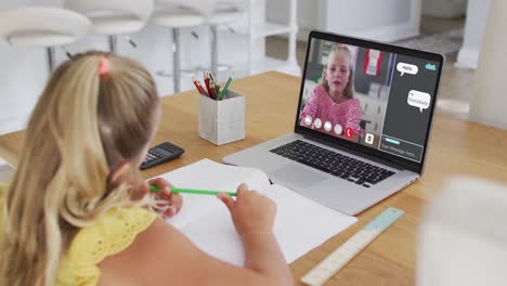 Caucasian-girl-doing-homework-and-having-a-video-call-with-classmate-on-laptop-at-home