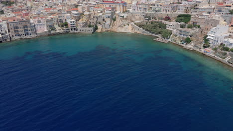 aerial: un avión no tripulado lento revela una toma de la playa de asteria en ermoupoli de siros, grecia