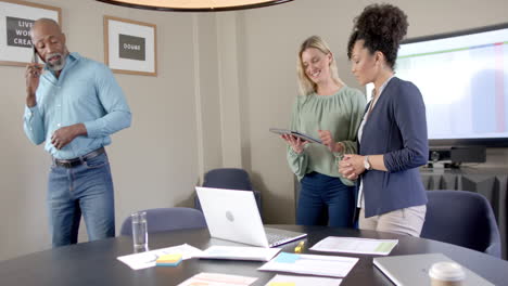 Diverse-business-people-using-laptops-at-conference-table-with-copy-space