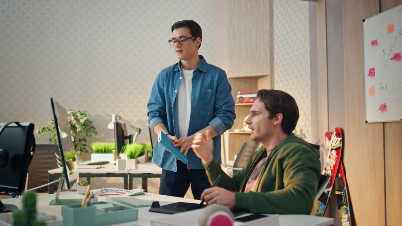 행복한 팀이 사무실 방에서 컴퓨터를 작동합니다. 두 명의 프리랜서가 프로젝트를 마무리합니다.