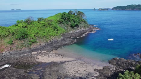 Pequeño-Bote-Anclado-En-Medio-De-Dos-Pequeñas-Islas