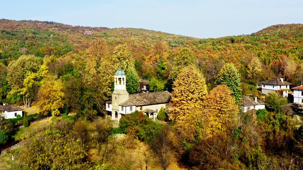 vuelo de avión no tripulado iglesia de la aldea búlgara otoño paisaje de bosque colorido
