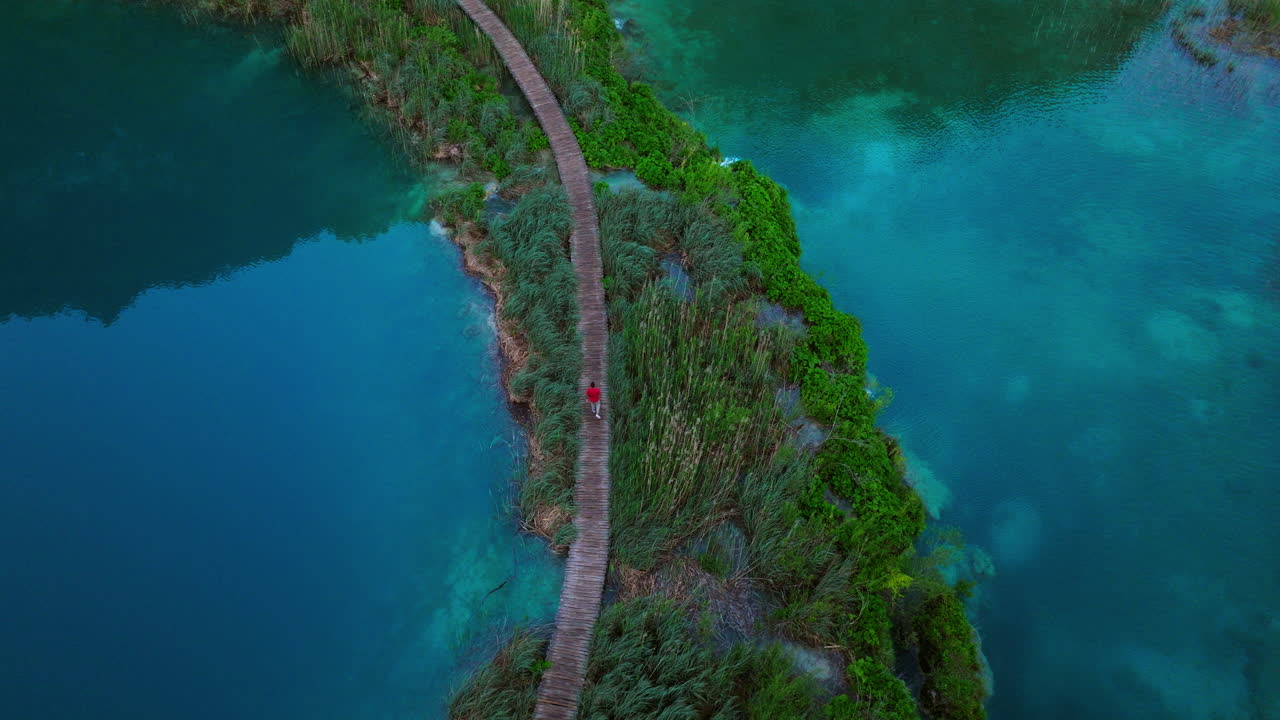 Aerial view of a person walking on a boardwalk in Plitvice Lakes