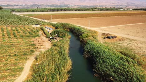 piscina natural longa e estreita no rio hakibbutzim em beit she&#39;an entre o vale de jezreel e o rio jorden em um dia de vento enquanto um carro dirige lentamente pela estrada de terra