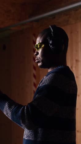 vertical video portrait of smiling man doing training in shooting range