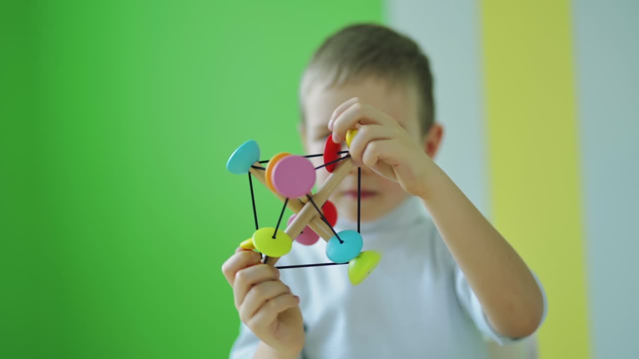 Child playing educational toy at home. Cute little kid playing developing games. Colorful toy in boy's hands in the room.
