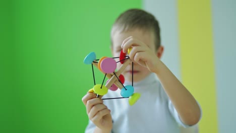 child playing educational toy at home. cute little kid playing developing games. colorful toy in boy's hands in the room.