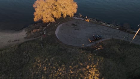 Un-Lago-En-Muskegon-Al-Atardecer,-Colores-Cálidos-Bañando-El-Agua-Y-La-Orilla