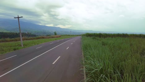 Ein-Jib-Shot-Einer-Leeren-Straße,-Umgeben-Von-Hohem-Gras