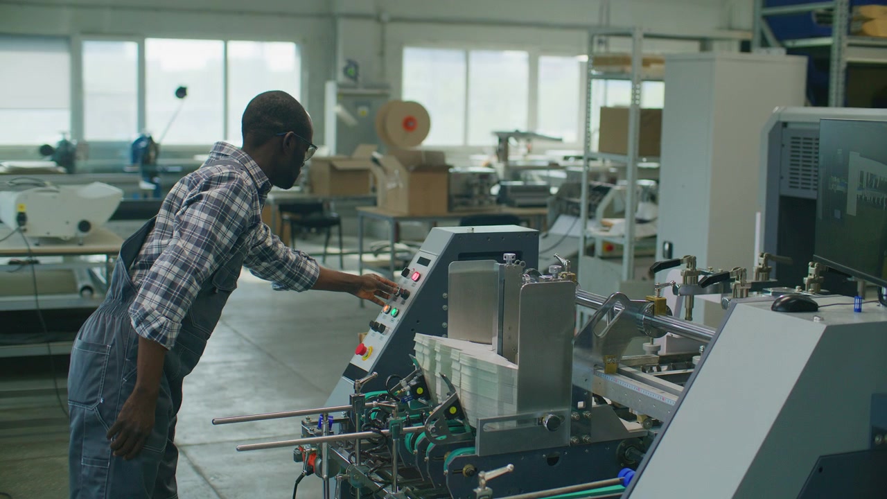 Printing Factory Worker Operating Automated Paper Processing Machine