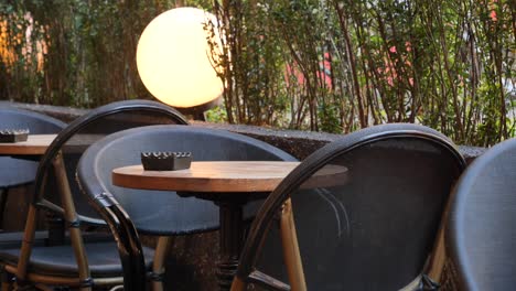 empty outdoor cafe table with chairs at night