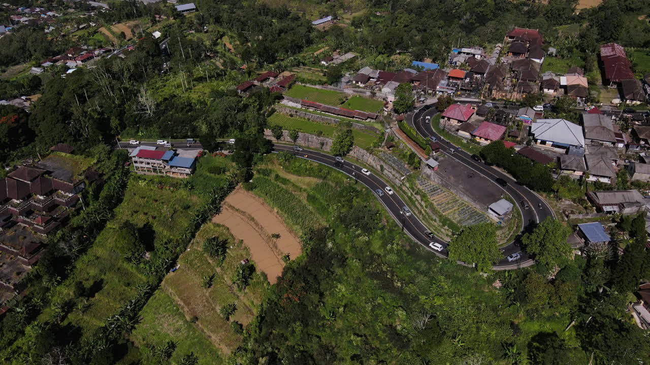 Tráfico circulando en carretera curva cerca de un pueblo pequeño en el norte de Bali, Indonesia