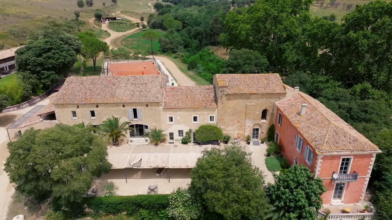 Inquadratura aerea di presentazione di una grande villa con campo da tennis a St Colombe.