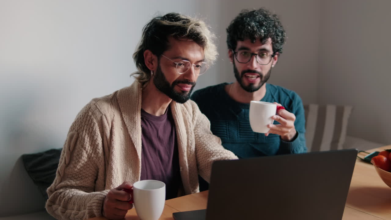 Gay Couple Enjoys Coffee and Laptop at Home