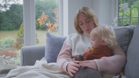 Mother-With-Son-Sitting-Under-Blanket-With-Pet-Dog-During-Cost-Of-Living-Energy-Crisis