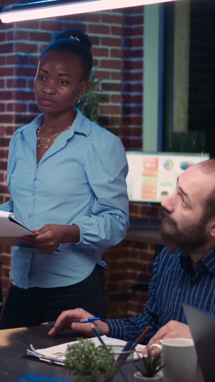 Vertical video: African american employees presenting company revenue statistics visualization