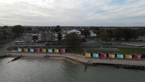 Beach-Huts-with-large-numbers-East-Beach,-Shoeburyness-panning-aerial-footage