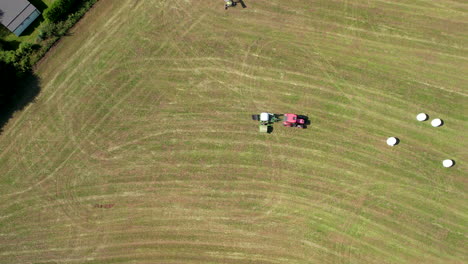 vista aérea de drones sobre tractores que atraviesan grandes tierras de cultivo en un día soleado