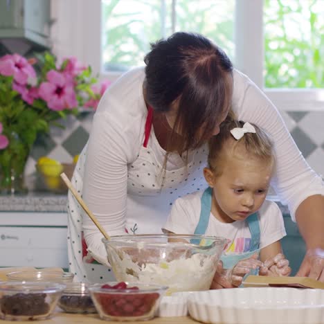 little girl helping her mum with the baking