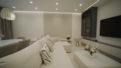 diseño y decoración de interiores modernos de sala de estar con sofá blanco en la sala de estar, mesa de comedor y sillas de madera, mostrador de cocina y armarios.