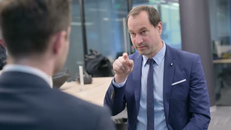 rear view of businessman talking to man in office