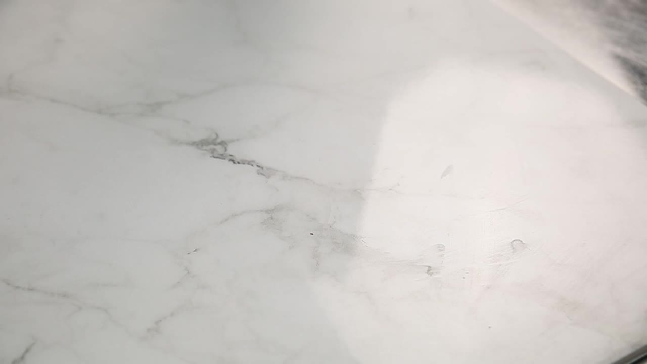 granos de cacao derramados de una bolsa en una superficie de mármol