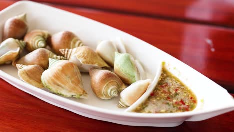 mariscos de conchas de alas hervidas con salsa picante